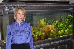 Директор супермаркета Аква Лого на Соколе Наталья Опаленко около эксклюзивного аквариума в резной облицовке.